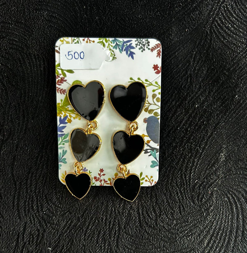 Black butterfly-shaped earrings on a floral card against a black textured background