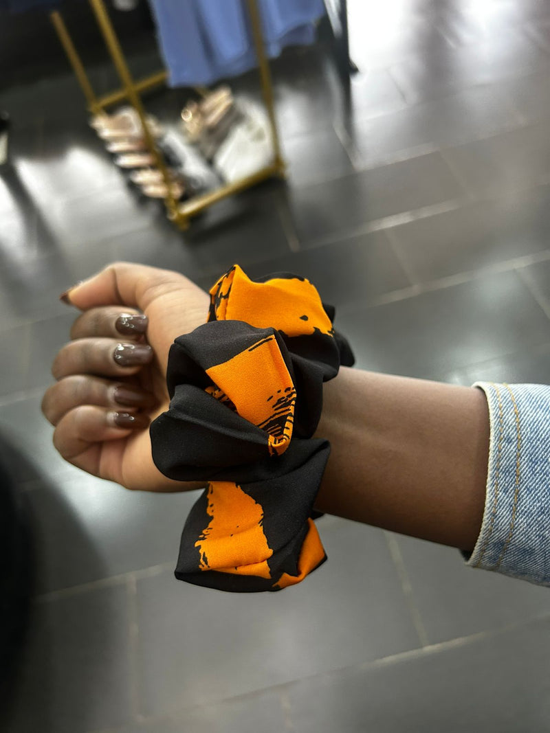 Hand holding a black and orange 